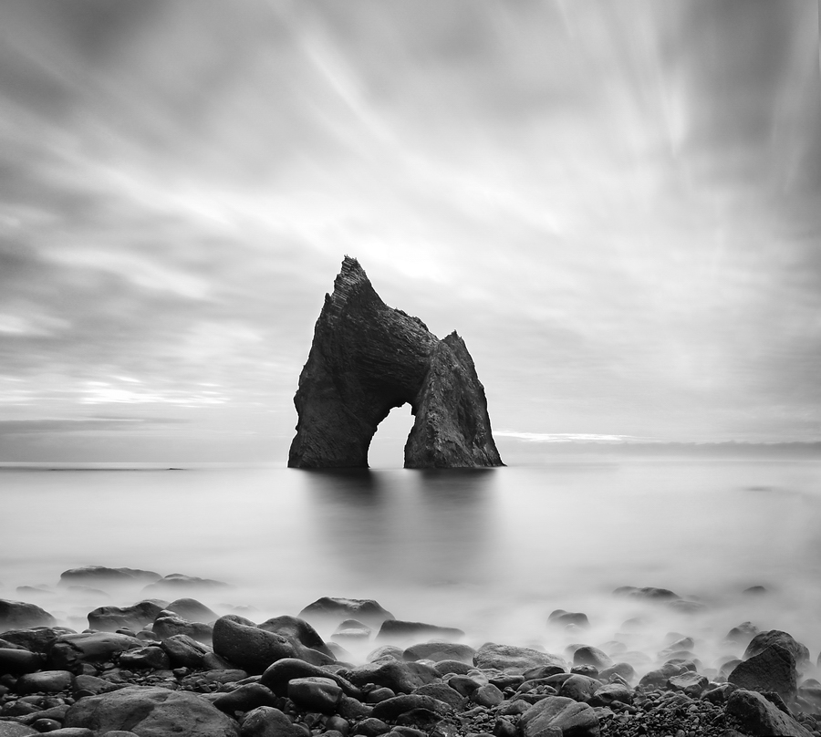 Archlike cliff | black and white, dull sky, shore, stones